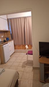 Una pequeña cocina con una ventana y una silla. en Jupi, en Pržno