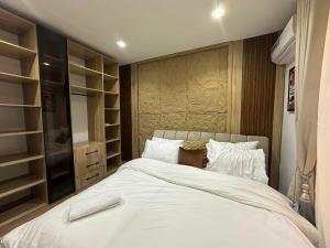 Un dormitorio con una gran cama blanca y estanterías en Luxury 1 Bedroom Apartment in Lekki, en Ikuata