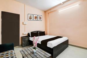 a bedroom with a bed and a table with flowers at HOTEL O THE INFINITY in Jādabpur