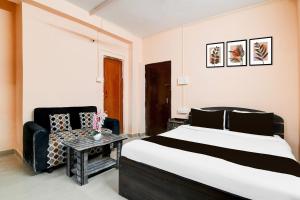 a bedroom with a large bed and a chair at HOTEL O THE INFINITY in Jādabpur