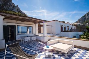 un patio con sillas, un sofá y una mesa en Casa Verdemare, en Capri