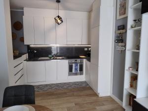 Una cocina con gabinetes blancos y un fregadero. en Your Roman Holiday Home, en Lido di Ostia