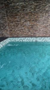a swimming pool with blue water and a brick wall at 1bed with pool and restaurant apartment in Accra