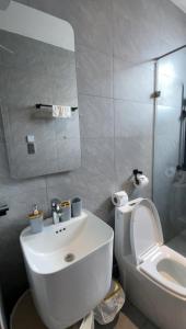 a bathroom with a white sink and a toilet at 1bed with pool and restaurant apartment in Accra