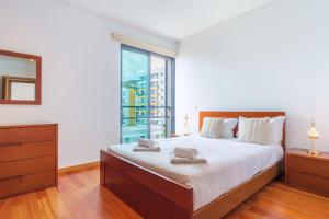 Un dormitorio con una cama grande y una ventana grande. en GuestReady - Modern space close to Formosa Beach, en Panasqueira 12 fotos más