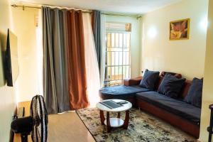 a living room with a blue couch and a table at Bright & Airy 2BR Haven in Kampala