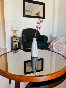 a vase with a flower on a glass table in a living room at The Spot in Xanthi