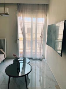 a living room with a glass table and a window at The Spot in Xanthi +8 photos