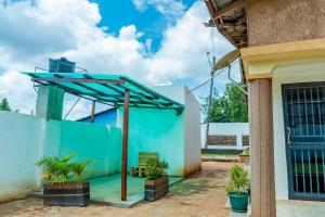 a blue building with a blue roof with plants at Bright & Airy 2BR Haven in Kampala