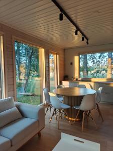 un salon avec une table et des chaises et une cuisine dans l'établissement Citymökki kaupungissa Joensuu, à Joensuu