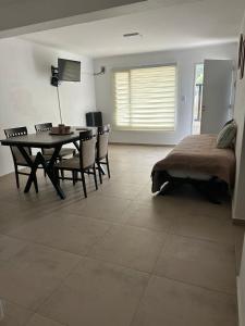 a living room with a table and chairs and a bed at Patagonia Cordilleras in Esquel