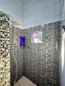 bagno con doccia e parete piastrellata di Top Houses Casa Serena em Arraial d'Ajuda a Arraial d'Ajuda