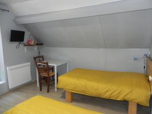 a bedroom with a yellow bed and a desk at VILLA LOZELOUX n 2 in Le Mont-Dore