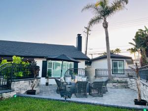 a patio with chairs and an umbrella in front of a house at Endless Summer Beach House in Huntington Beach