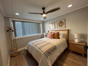 a bedroom with a bed with a ceiling fan at Endless Summer Beach House in Huntington Beach +45 photos