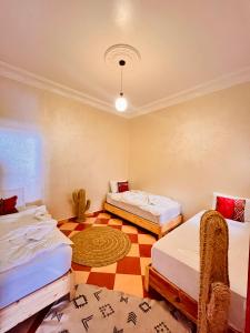a room with two beds and a checkered floor at All-Inclusive Surf Packages and Activity Everyday in Agadir