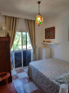 a bedroom with a bed and a large window at Villa Coral in Chiclana de la Frontera