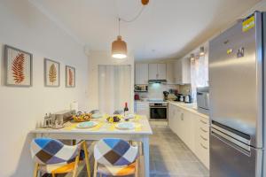 a kitchen with a table with chairs and a refrigerator at Drosoula House in Agios Georgios