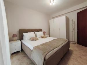 a bedroom with a large bed and a white cabinet at PERLA apartment in Alexandroupoli