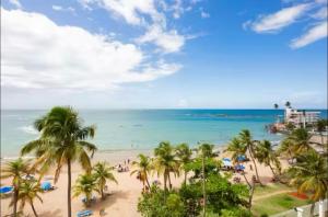 a view of a beach with palm trees and the ocean at Tropĭmar Suites 2BR Modern Beach Escape New! in San Juan