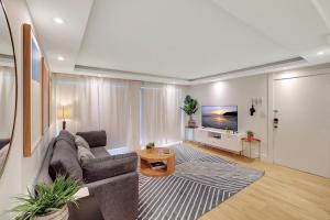 マイアミビーチにあるModern 2Bedroom in South Beach - Steps away from Lincoln Rdのソファとテレビのあるリビングルーム