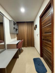 Cette petite chambre comprend un bureau et une porte. dans l'établissement The Starlit Stays - Urban Nest, à Siroli 11 autres photos