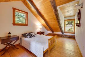 a bedroom with a bed and two windows at Remote Escape Vermont Cabin with Mountaintop Views! in Sharon