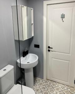 a bathroom with a white toilet and a sink at Charming Historic Apartment F2 in Tbilisi City +4 photos