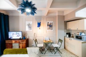 a living room with a kitchen and a table with chairs at Blue Camel in Old Town in Bucharest