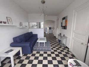 a living room with a blue couch and a checkered floor at Charmant appartement Pornic in Pornic