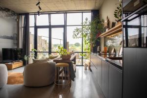a living room with a table and some plants at Het Maashuys in Arcen