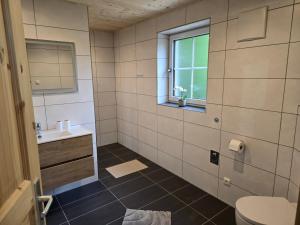 a bathroom with a sink and a toilet and a window at Klettnerlehen in Ramsau +29 photos