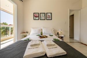 a bedroom with a bed with two towels on it at 200m da praia com Piscina ,churrasqueira e Jacuzzi in Bertioga