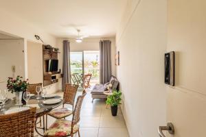 a living room with a dining room table and chairs at 200m da praia com Piscina ,churrasqueira e Jacuzzi in Bertioga