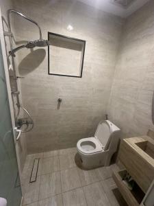 a bathroom with a toilet and a shower at شقة أنيقة غرفة وصالة بأثاث فندقي in Dammam