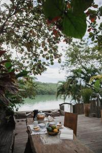 una mesa con un bol de fruta y vistas al río en Cabana Rio Caraiva, en Caraíva