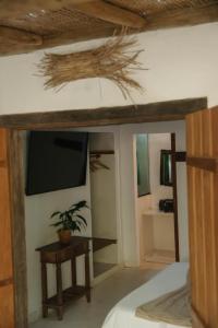 Un dormitorio con una cama, una mesa y un televisor. en Cabana Rio Caraiva, en Caraíva