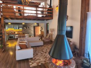 a living room with a fireplace in the middle of a room at Casa de campo Aconchego Serrano in Lages