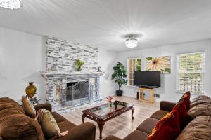 a living room with a couch and a fireplace at Lilburn Gateway with Game Loft, Fire Pit, Stone Mountain in Snellville
