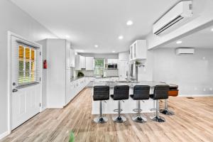 a kitchen with white cabinets and a counter with stools at Lilburn Gateway with Game Loft, Fire Pit, Stone Mountain in Snellville +57 photos