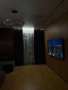 a living room with a tv on a wall at Экспо резиденция in Astana