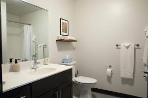 a white bathroom with a sink and a toilet at Deer District Studio Apt - One Block from Fiserv and Baird in Milwaukee +15 photos
