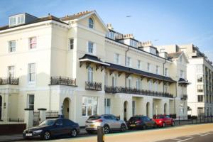 un grand bâtiment blanc avec des voitures garées devant dans l'établissement 2bed Seafront Flat Private roof terrace Parking, à Southsea