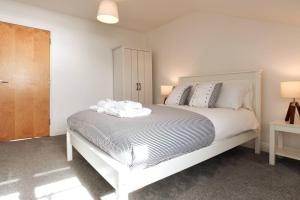 une chambre avec un grand lit blanc avec deux lampes dans l'établissement 2bed Seafront Flat Private roof terrace Parking, à Southsea