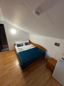 a small bedroom with a bed with a blue blanket at Pensiune Raul&Iulia in Baile Felix +91 photos