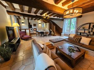 a large living room with a couch and a tv at Villa familiale La Finca du champ de l'eau Avec sauna jacuzzi proche de Disney et Paris in Crecy la Chapelle