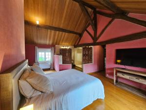 a bedroom with a white bed and a flat screen tv at Villa familiale La Finca du champ de l'eau Avec sauna jacuzzi proche de Disney et Paris in Crecy la Chapelle +49 photos