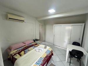 a small room with two beds and a chair at Suíte da paz in Lauro Müller
