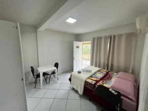 una camera da letto con un letto, un tavolo e una scrivania di Suíte da paz a Lauro Müller