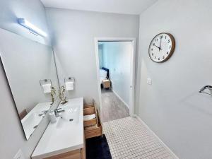a bathroom with a sink and a clock on the wall at Cloud Nine Studio in Des Moines +30 photos
